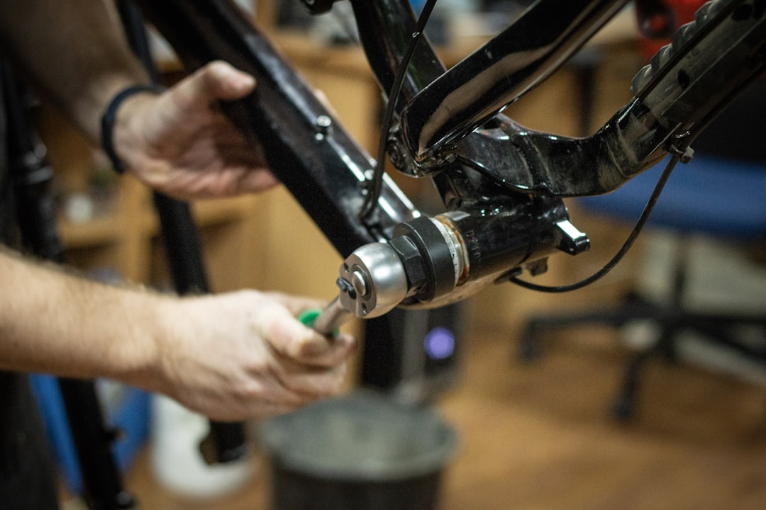 Bicycle mechanic working on bike in workshop - Unsplash photo by Bohdan Kadun