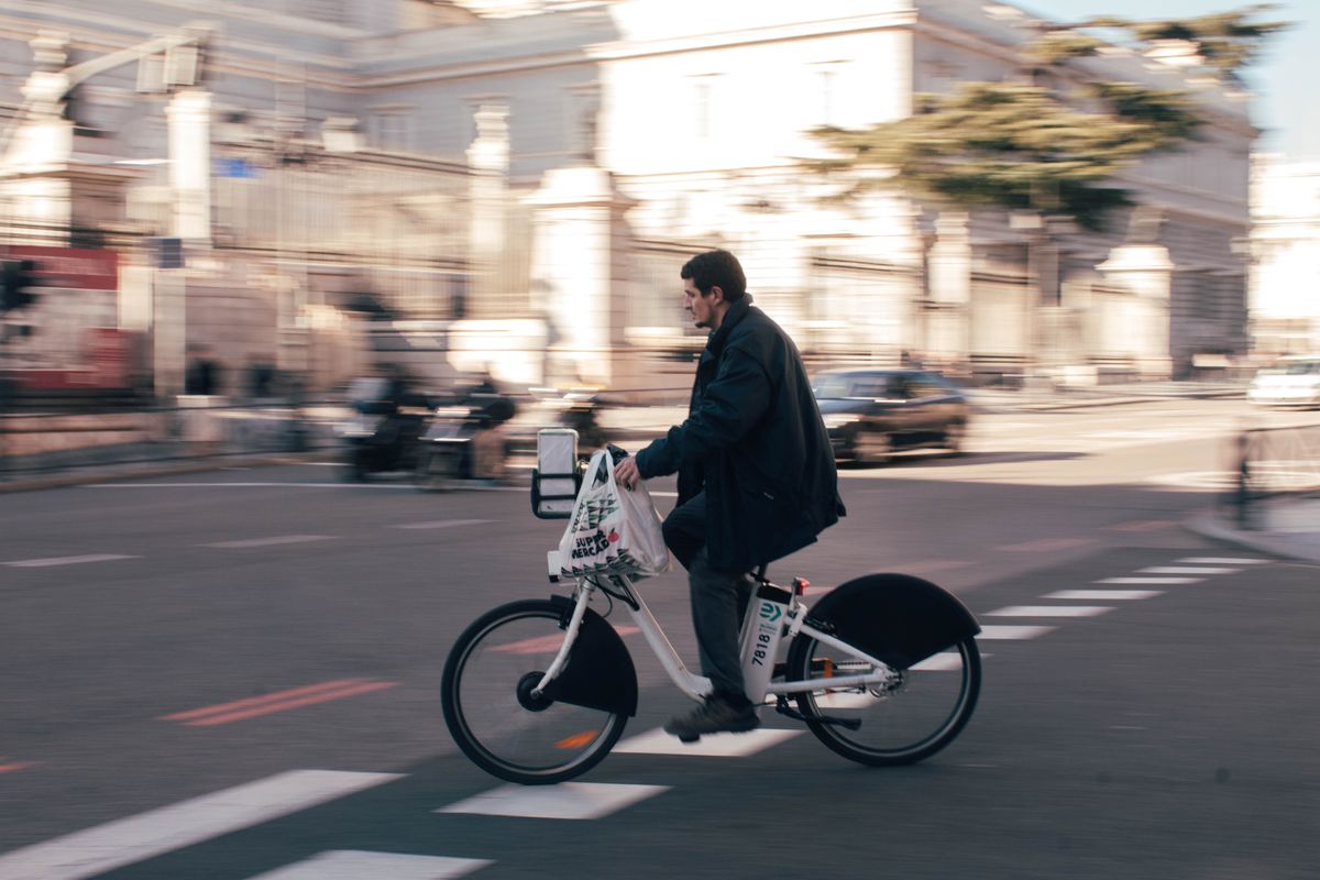 Man riding electric bike through European city street — real commute photo